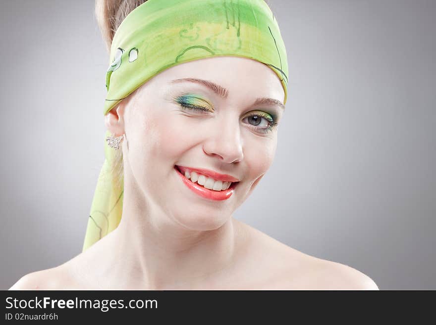 Closeup portrait of smiling winging woman with beautiful green eyes and green bandage on head