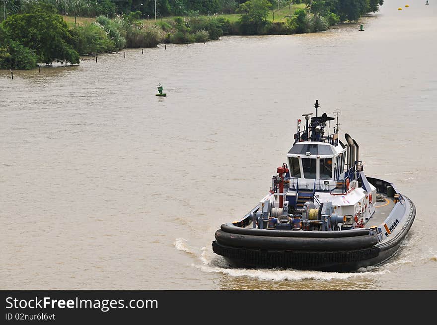 Tugboat accompanies ship in the Panama Channel