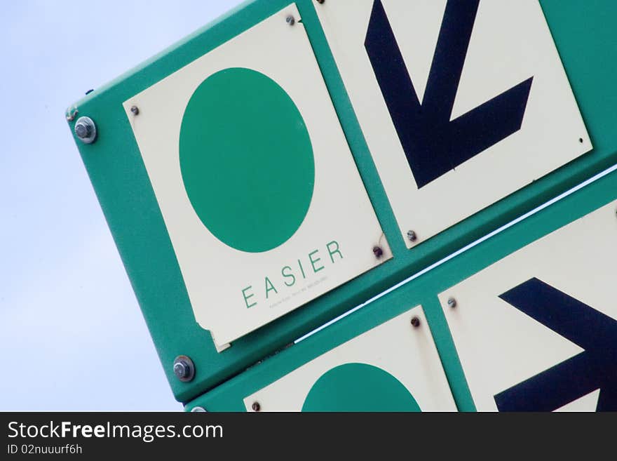 A trail sign at a Colorado ski resort points toward easy trails. A trail sign at a Colorado ski resort points toward easy trails.