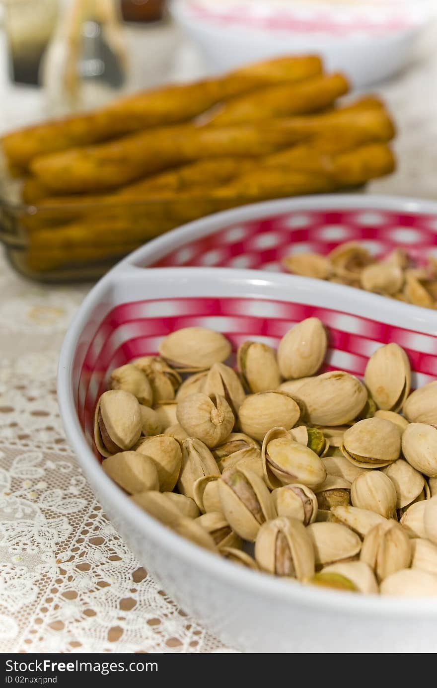 Pistachios on plate and salted sticks