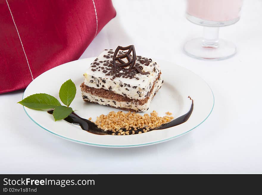 Sweet chocolate dessert with nuts and chocolate on white plate and red napkin