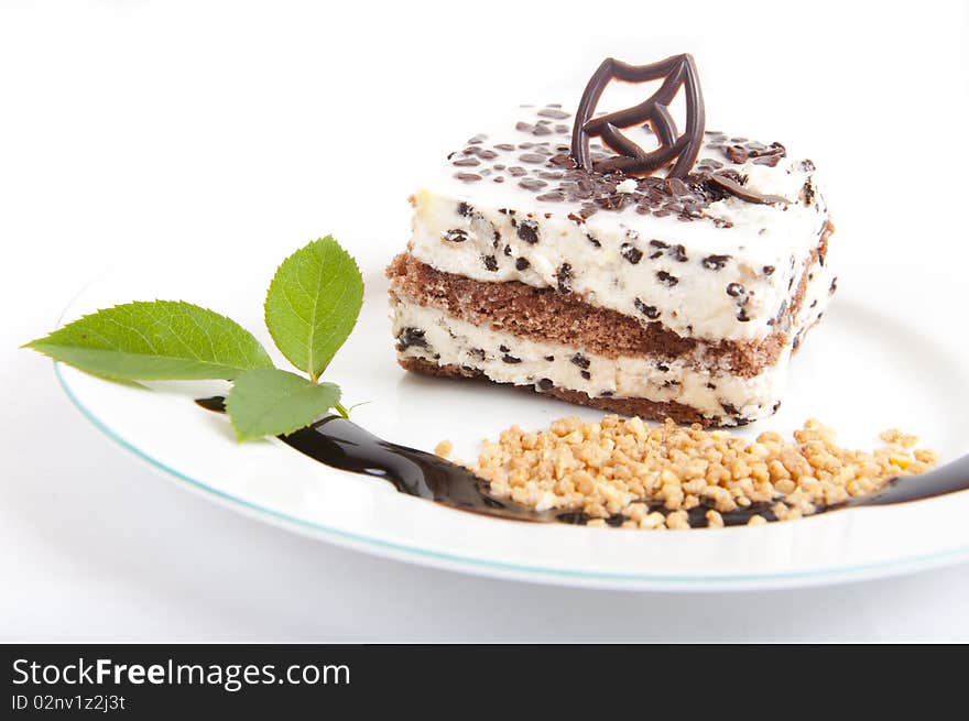 Sweet chocolate dessert with nuts and chocolate on white plate