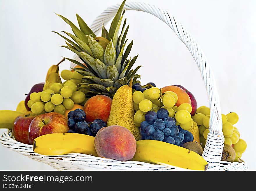 White fruit basket banana peach, pear, grapes