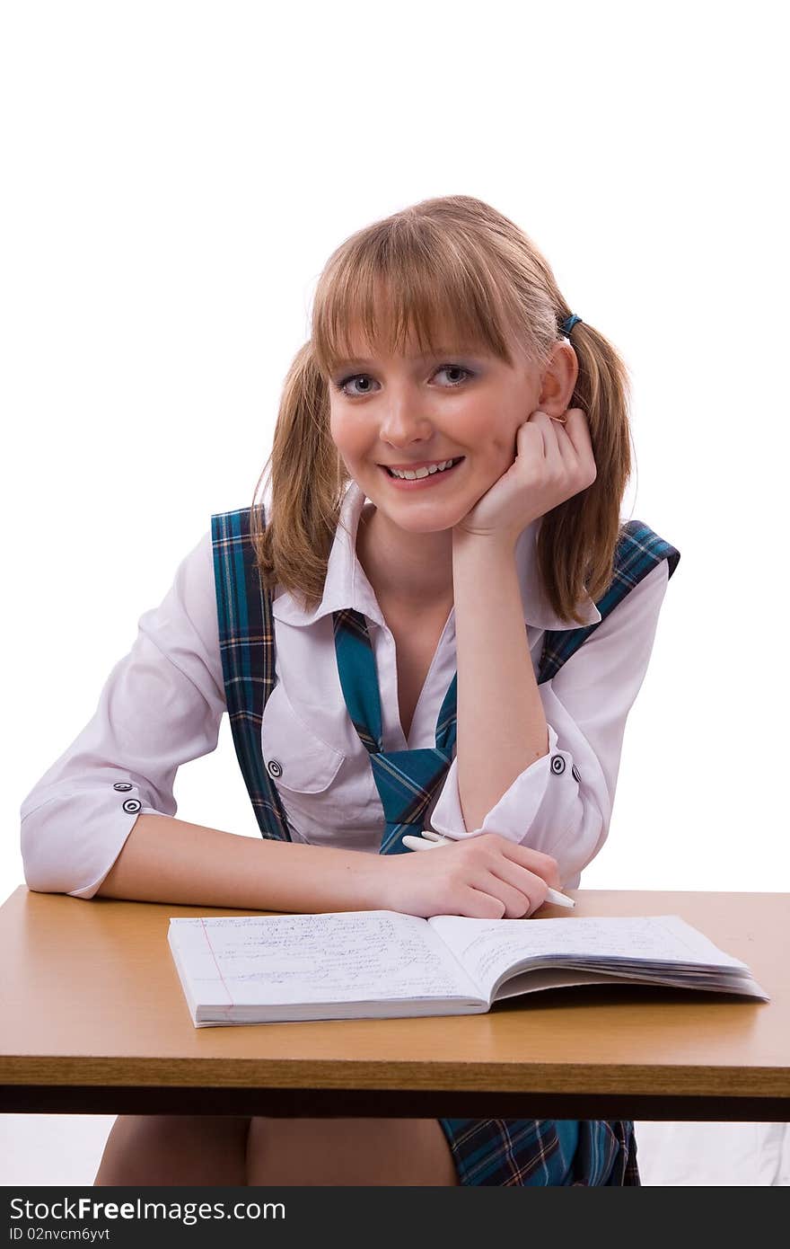 Portrait of a sweet little girl at her classroom, writing an exam. A happy schoolgirl doing her homework. Young student writing.