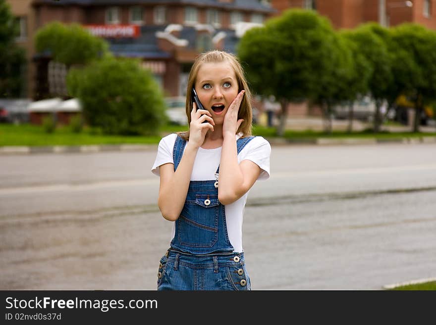 Woman is talking mobile phone outdoors.