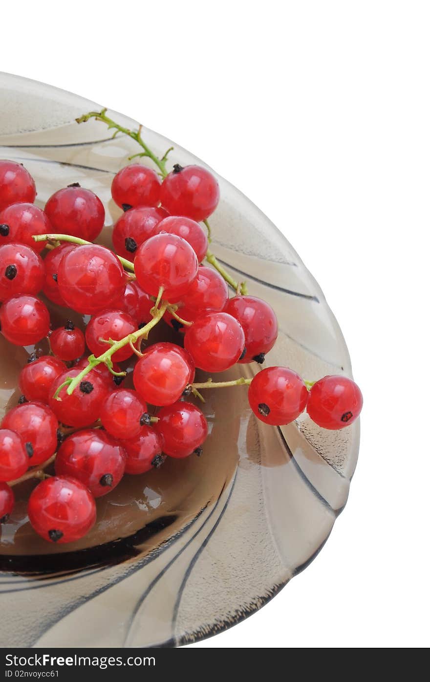 Picture of clusters of red currant on a dish on a white background