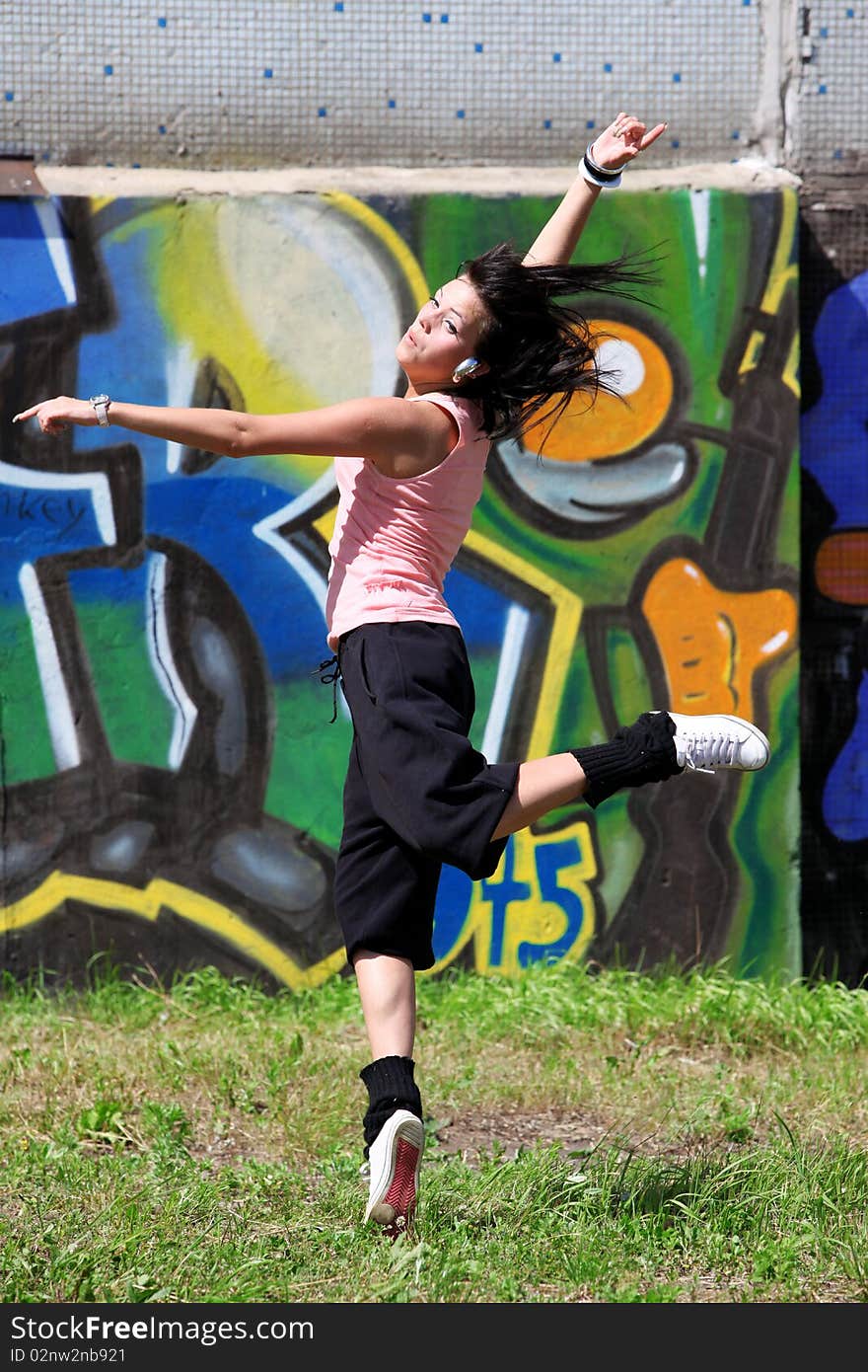 Woman modern ballet dancer in sity against graffiti wall