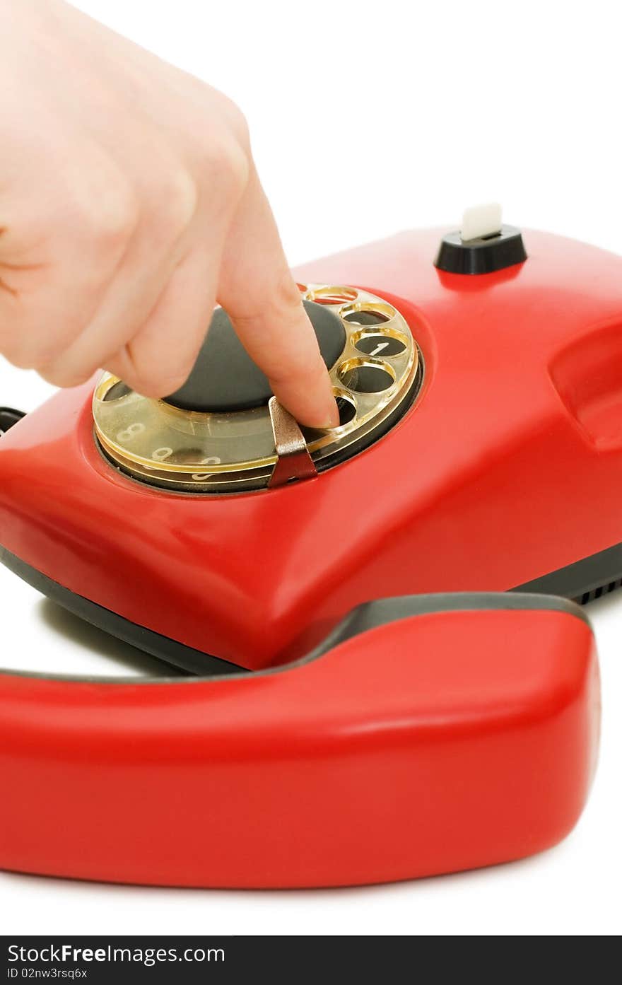 The girl dials number on red phone close up