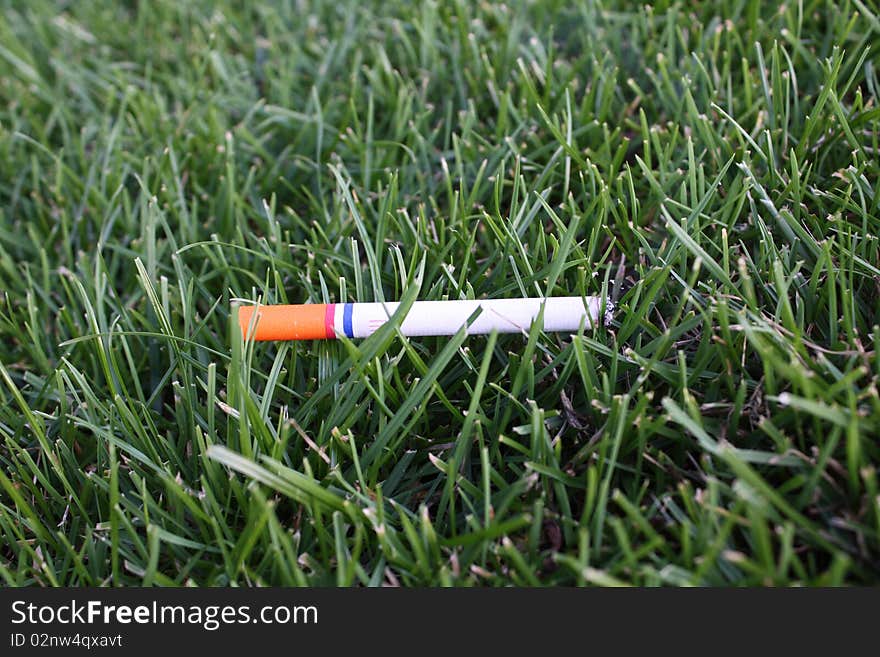 Orange red-white-blue ciggy in Dutch grass. Orange red-white-blue ciggy in Dutch grass