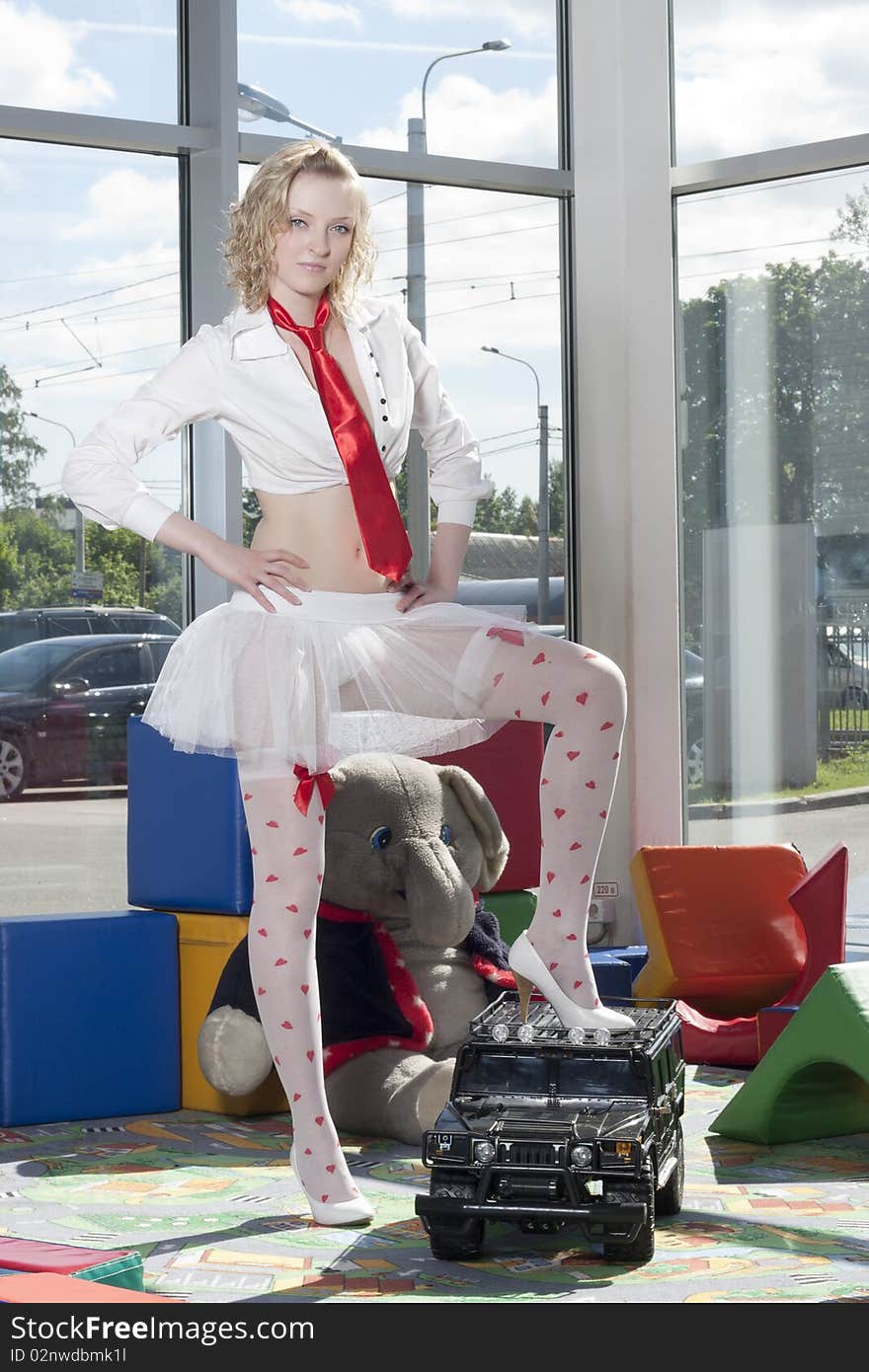 Fashion model stylized as babydoll with toy car at the nursey. Dealer autocentre LAURA in St.-Petersburg