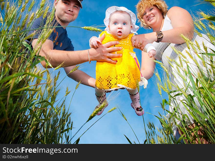 Funny baby in parents arms at summer wheat. Funny baby in parents arms at summer wheat