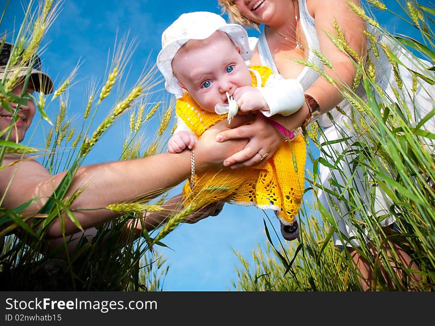 Funny baby in parents arms at summer wheat. Funny baby in parents arms at summer wheat