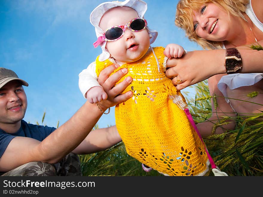 Funny baby in parents arms at summer wheat. Funny baby in parents arms at summer wheat