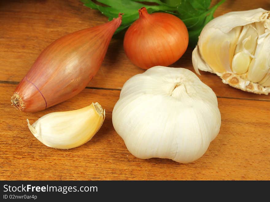 White garlic, shallot onion and parsley on wooden board. White garlic, shallot onion and parsley on wooden board.