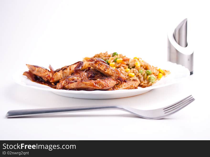 Stifried vegetable rice with soy and spices and fried pork with onions and tomatos. Stifried vegetable rice with soy and spices and fried pork with onions and tomatos