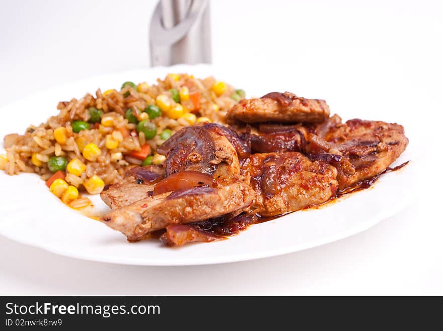 Stifried vegetable rice with soy and spices and fried pork with onions and tomatos. Stifried vegetable rice with soy and spices and fried pork with onions and tomatos