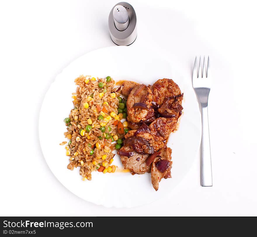 Stifried vegetable rice with soy and spices and fried pork with onions and tomatos. Stifried vegetable rice with soy and spices and fried pork with onions and tomatos