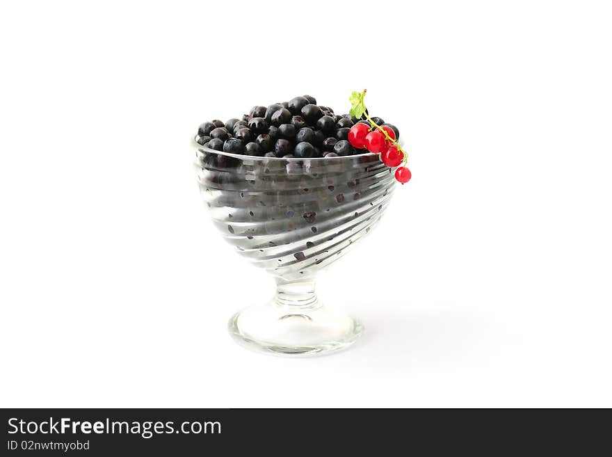 Blueberries and red currant in a glass bowl isolated on white. Blueberries and red currant in a glass bowl isolated on white