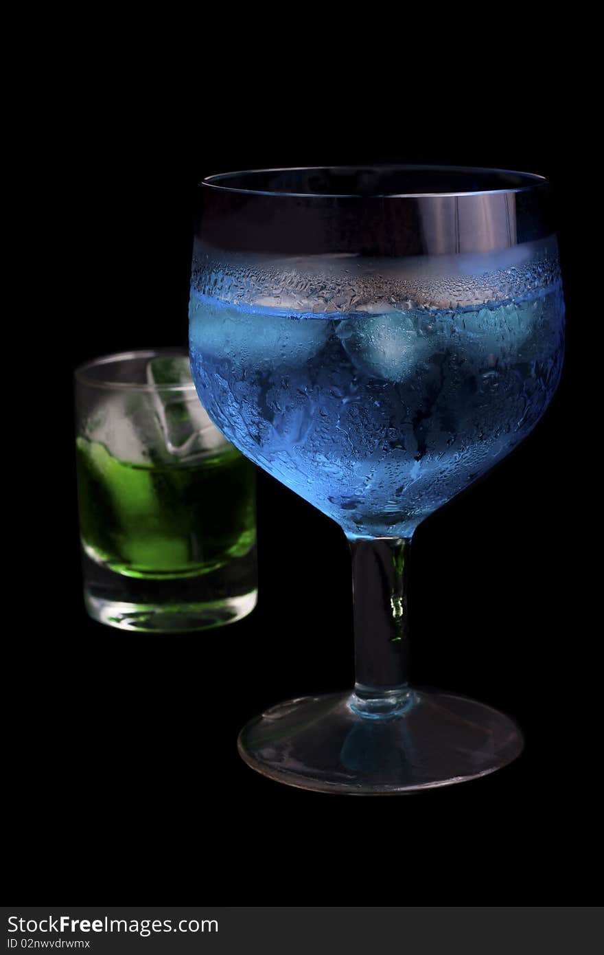 Blue Curacao and absinthe in a  glass on a black background