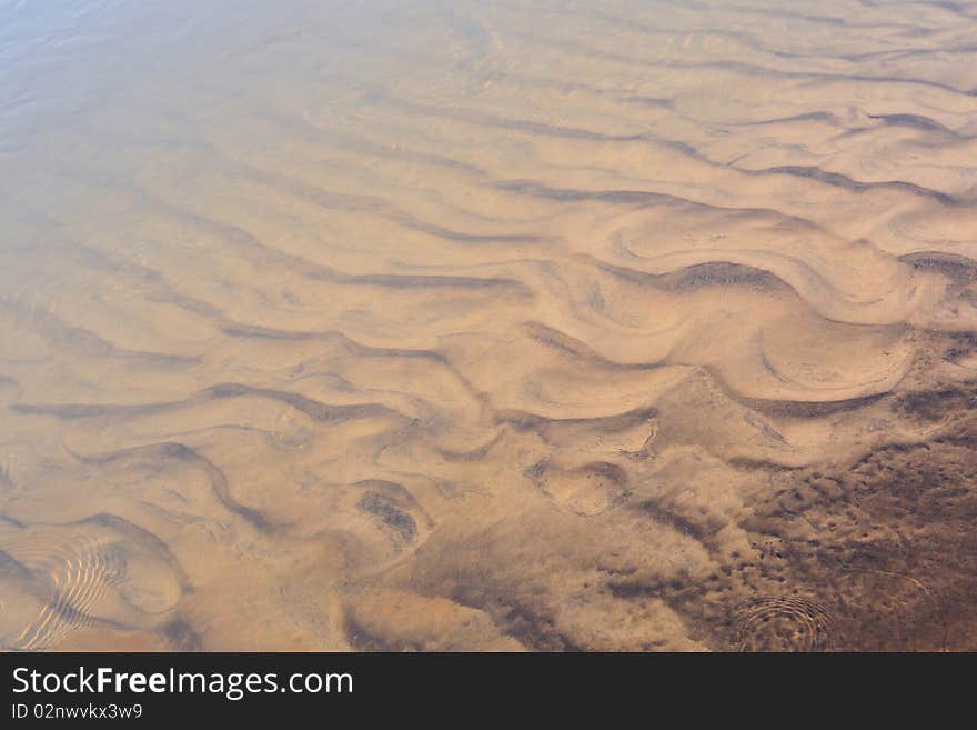 Scenic sand waves on the river bottom under transparent water stream