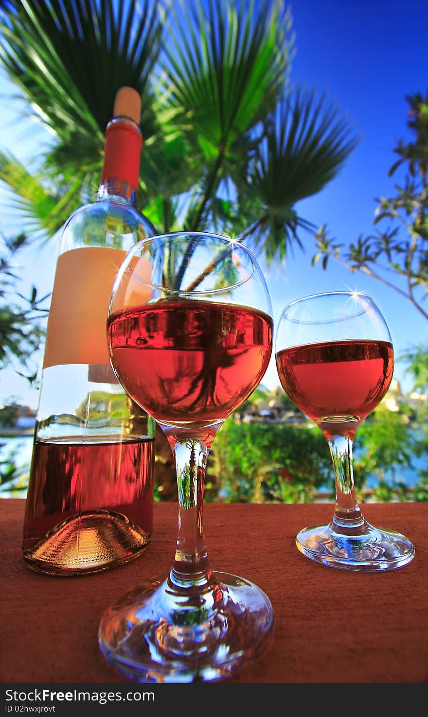 Two wineglasses. Background of the sea and the blue sky