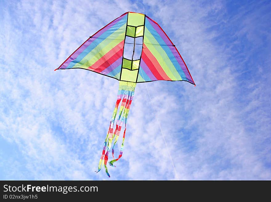 Bright multicolored kite in blue sky