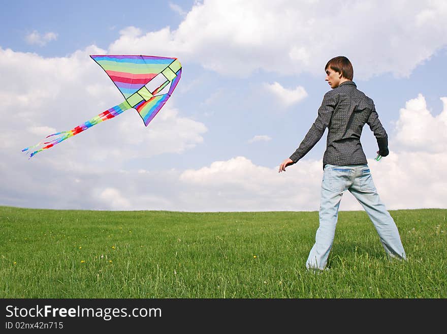 Young man in black shirt flying multicolored kite