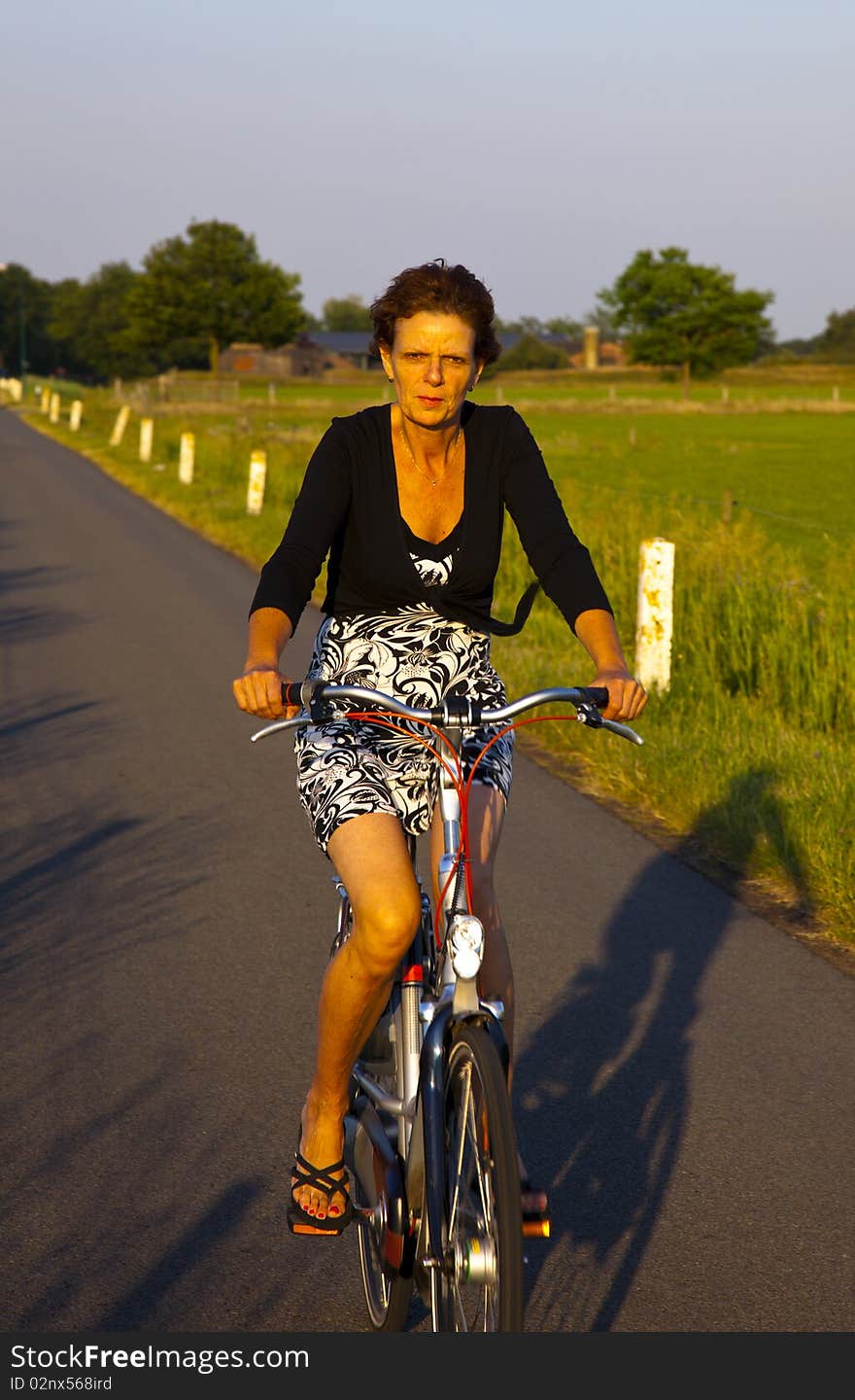 A women on a bicycle with evening light