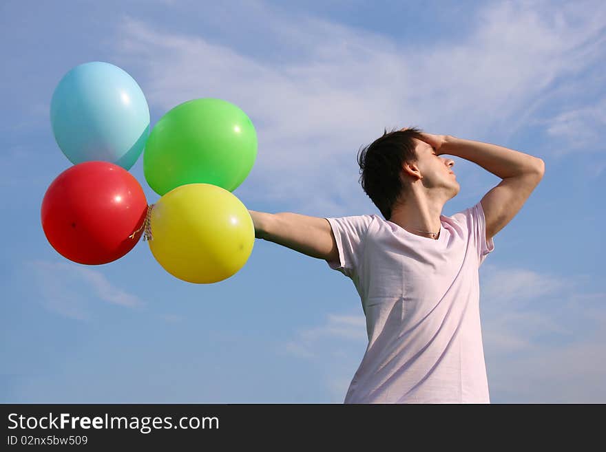 Young man with many colored balloons