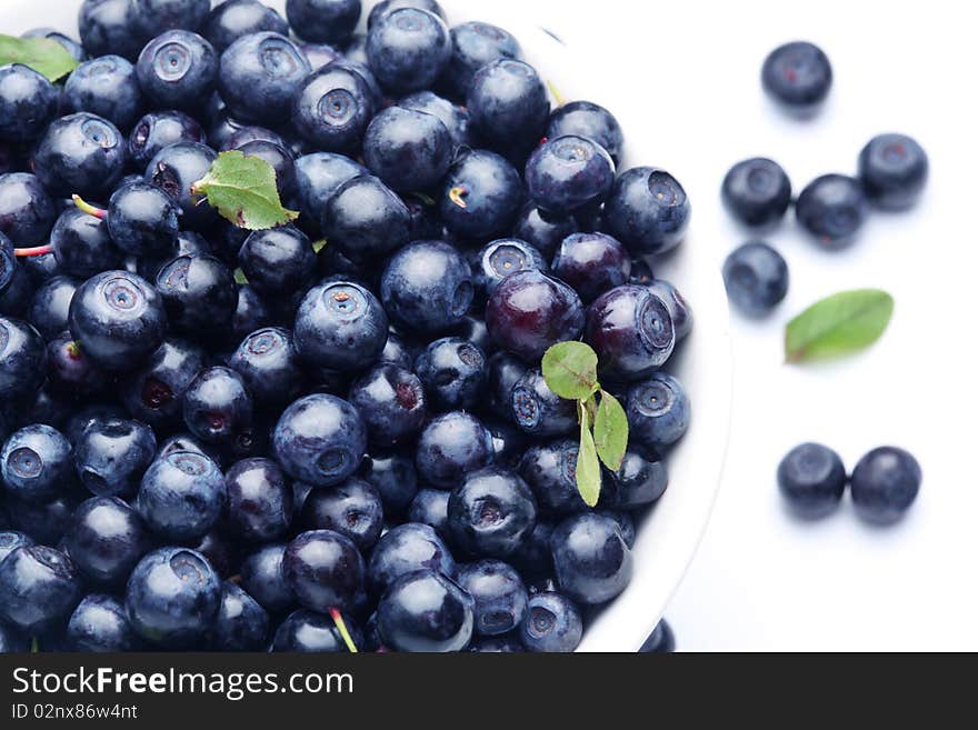 Crockery with blueberries.Some berries lay near the crockery.