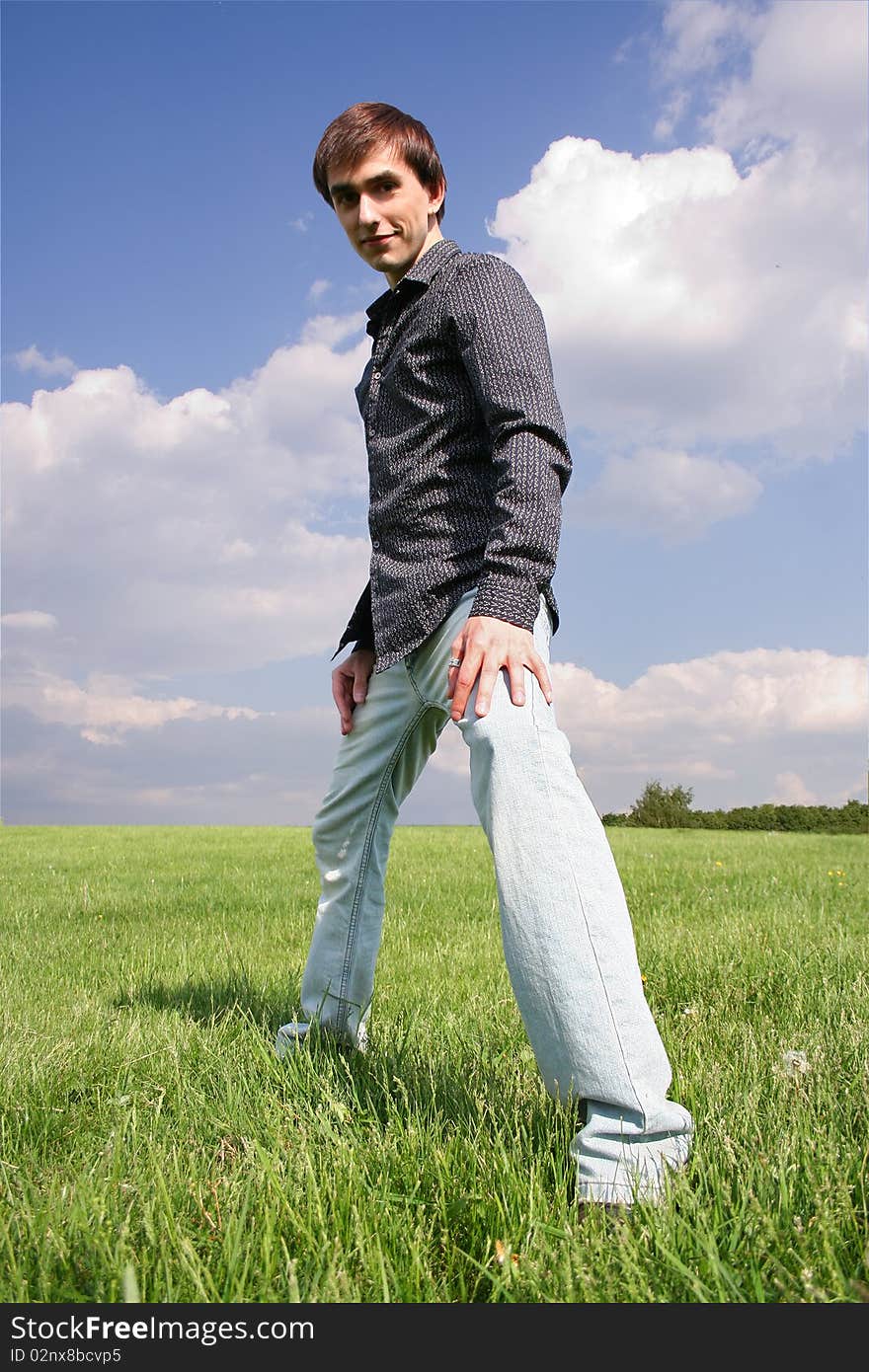 Young man in black shirt standing on green lawn