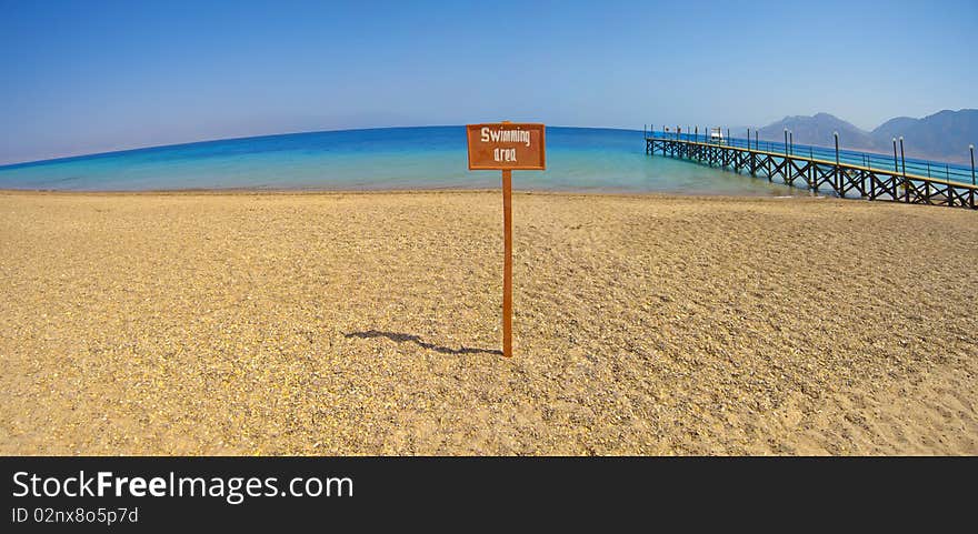 Panoramic view from a tropical beach with swimming area sign. Panoramic view from a tropical beach with swimming area sign