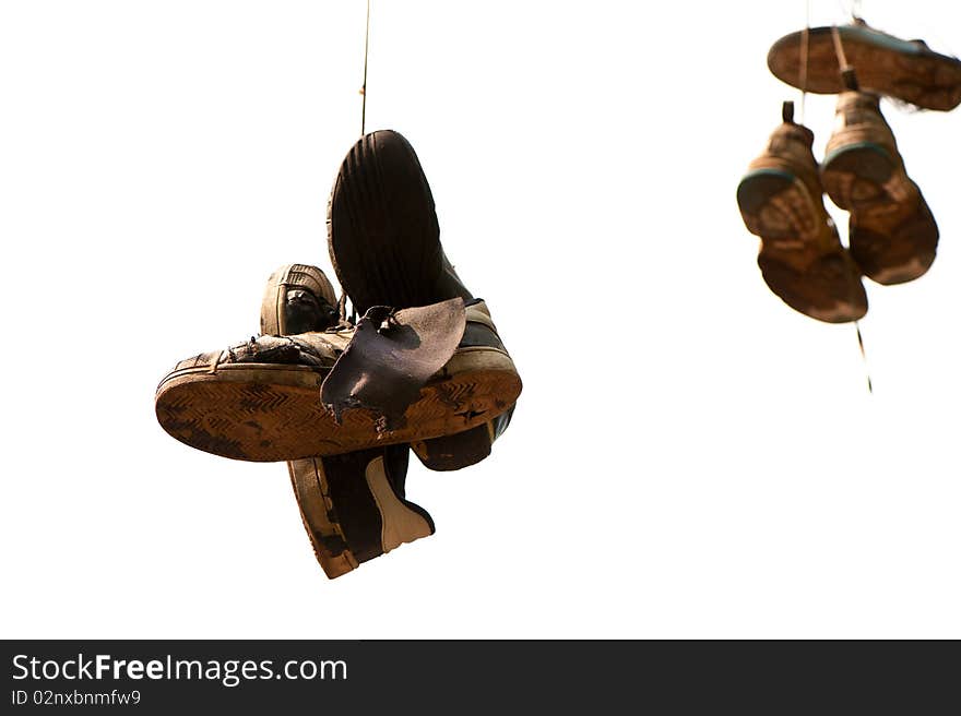 Old, torn  up sporting trainers  entangled by a lace on a light background. Old, torn  up sporting trainers  entangled by a lace on a light background