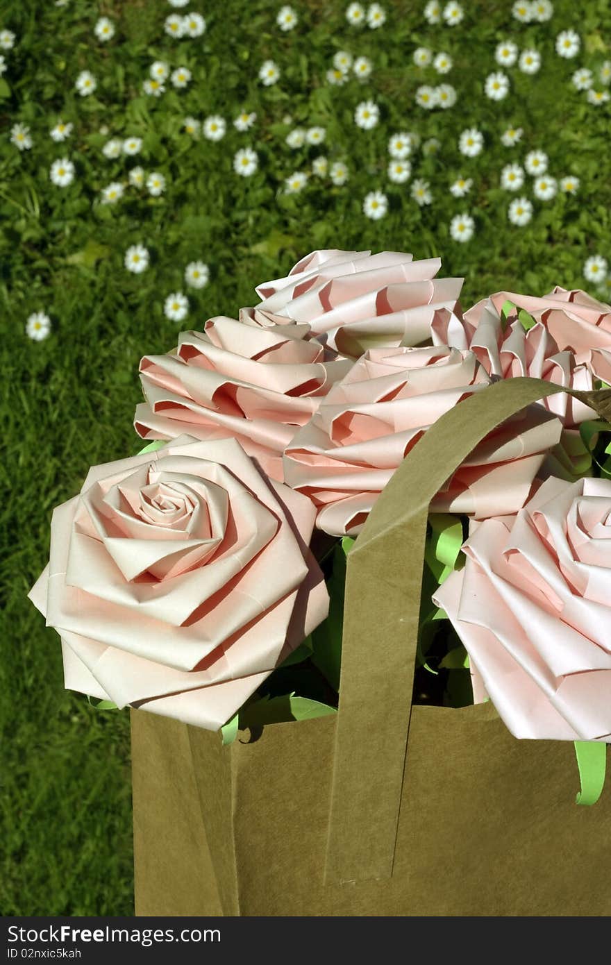 Pink paper roses in a brown paper bag