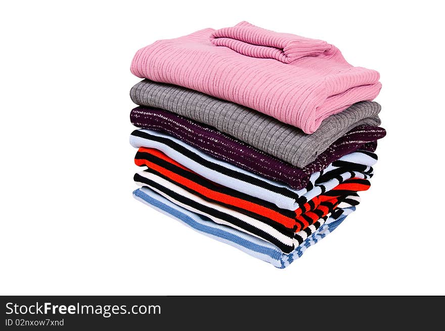 Stack of colorful winter sweaters  on a white.