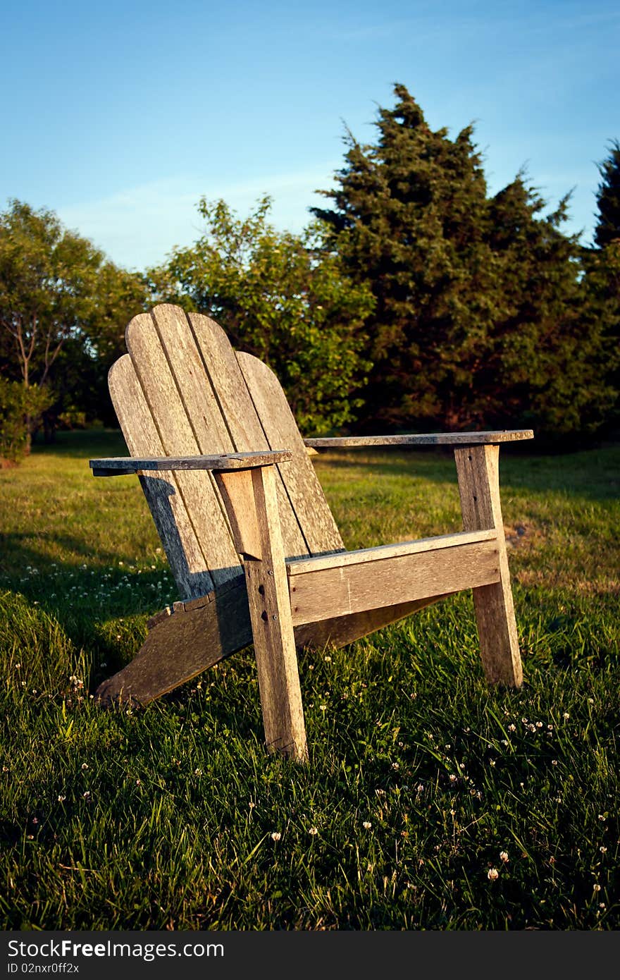 Empty chair in a meadow facing the sunset. Empty chair in a meadow facing the sunset