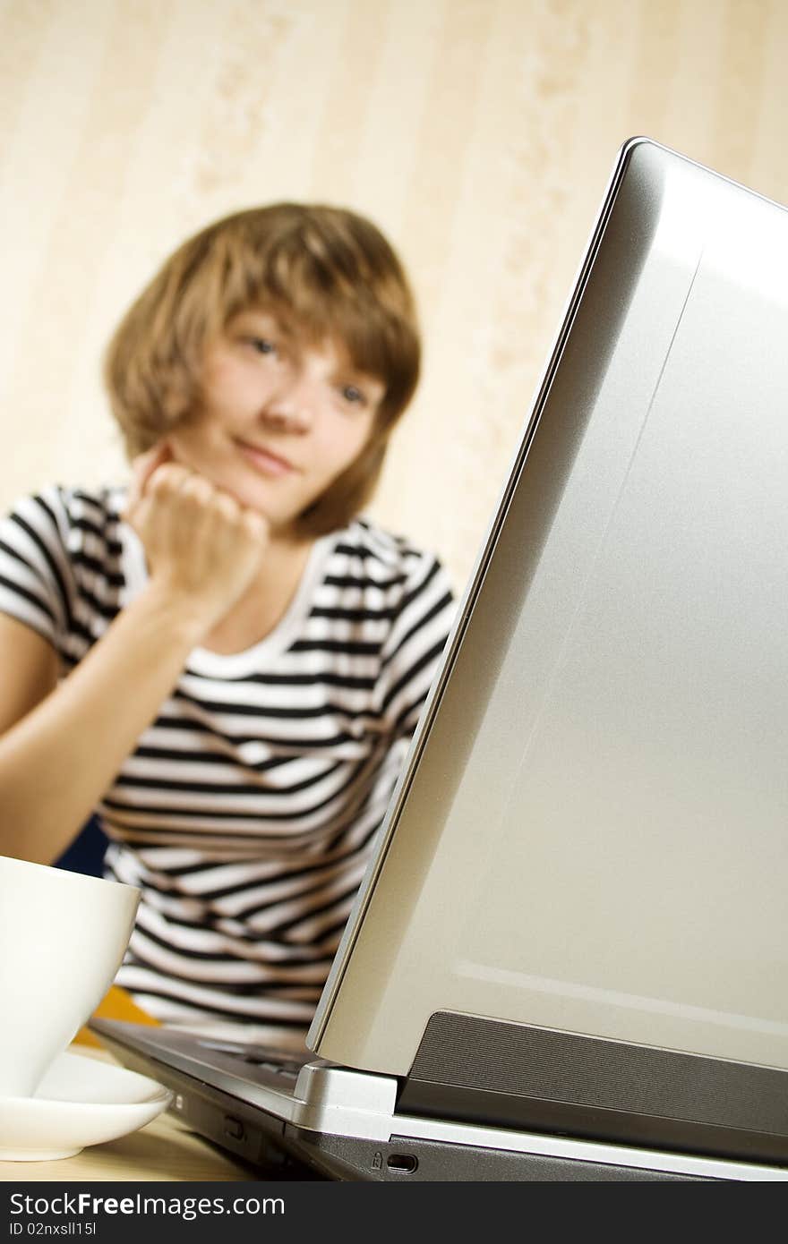 A young lady sitting on a sofa and using a laptop. A young lady sitting on a sofa and using a laptop.