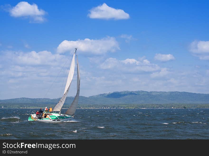 A yacht on the lake with the mountains in the background