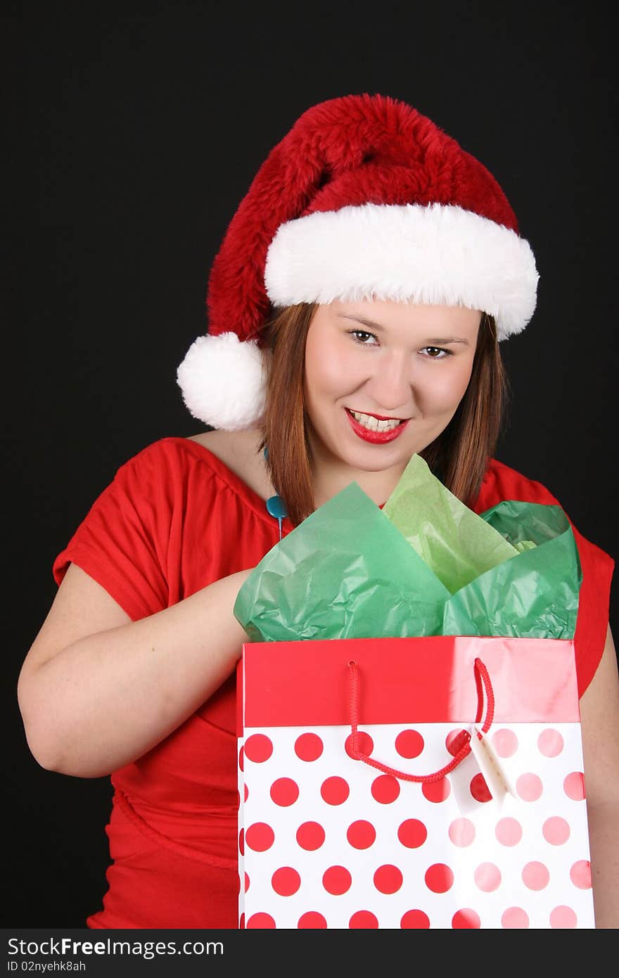 Cheerful young brunette wearing a red top and christmas hat. Cheerful young brunette wearing a red top and christmas hat