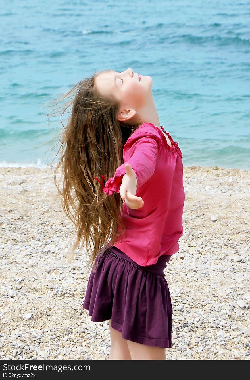 Happy girl by the sea in summer