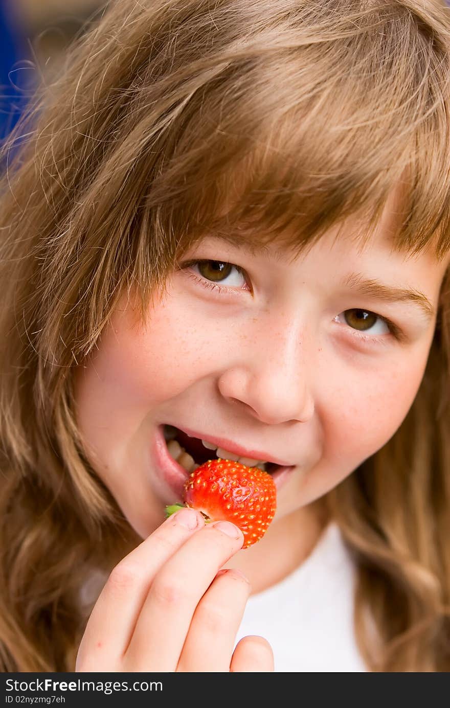 The girl eats the strawberry broken from a bed. The girl eats the strawberry broken from a bed