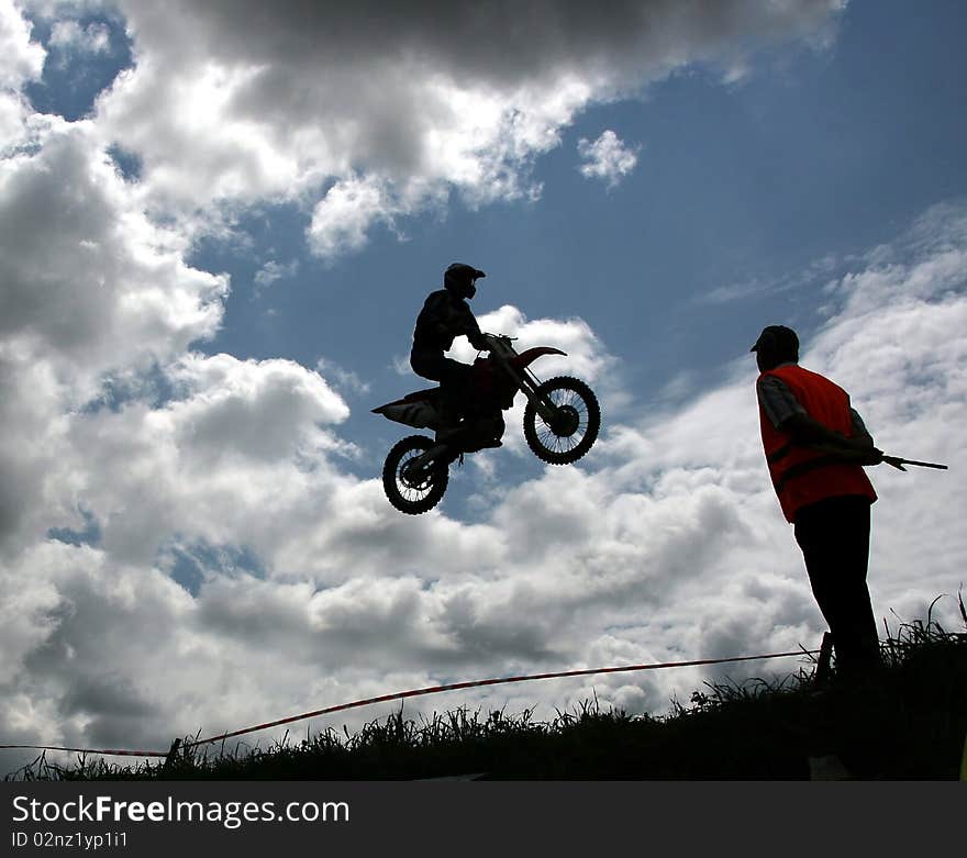 Motorcross rider jumping high at a jump