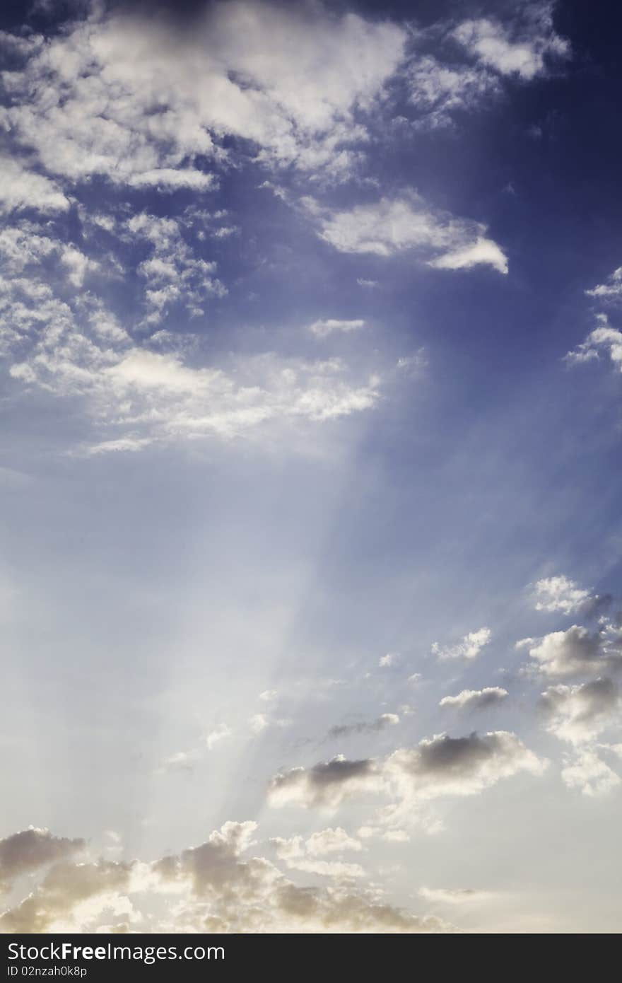 Sunset with rays with small clouds in the sky