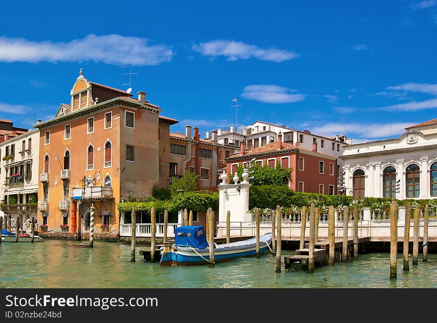 Venice canal with old buildings and piers