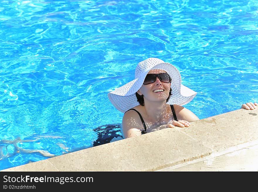 Woman in a pool relaxing in summer time