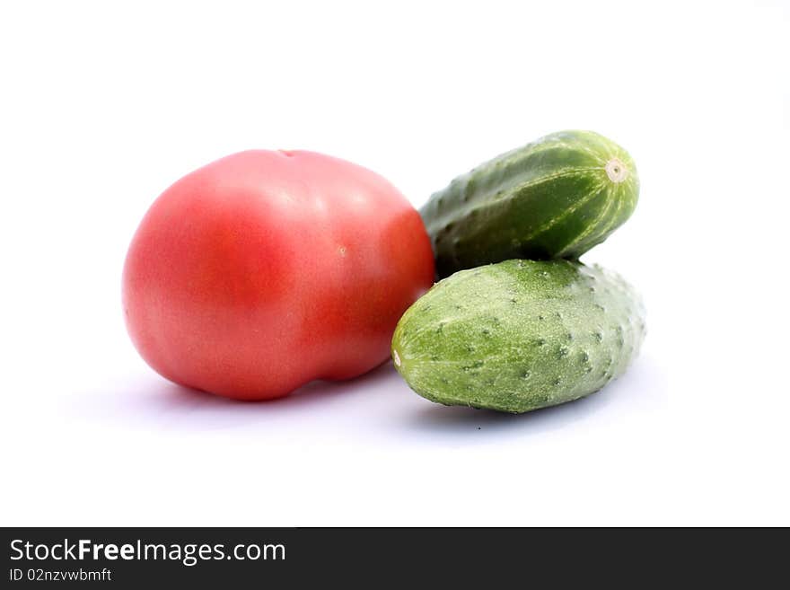 Red tomato and green cucumber on white background. Red tomato and green cucumber on white background