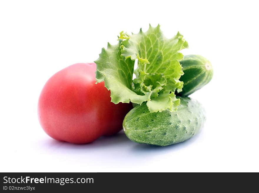 Red tomato and green cucumber on white background. Red tomato and green cucumber on white background