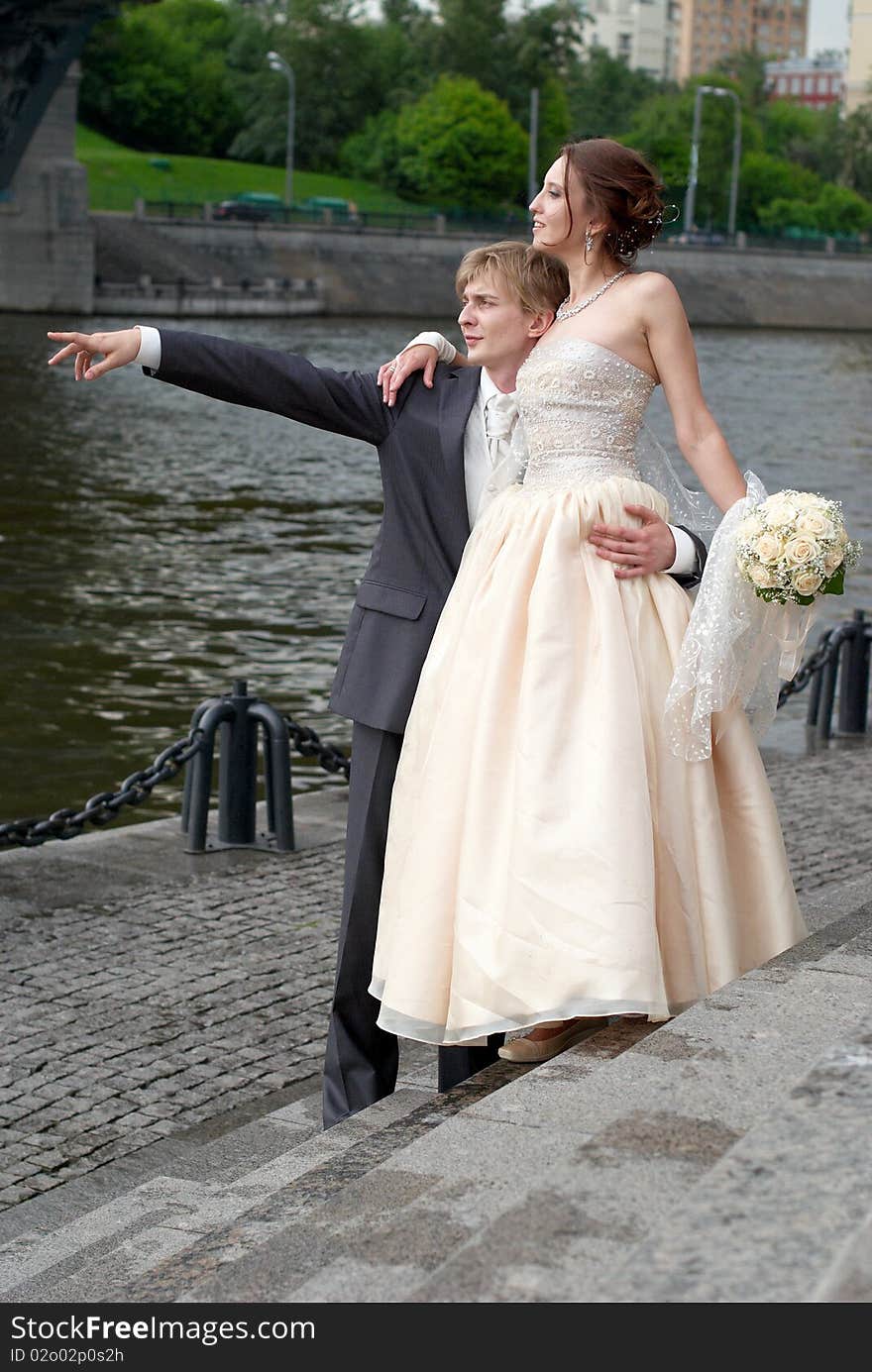 Newly married couple looking away in the same direction which is pointed by groom. Newly married couple looking away in the same direction which is pointed by groom