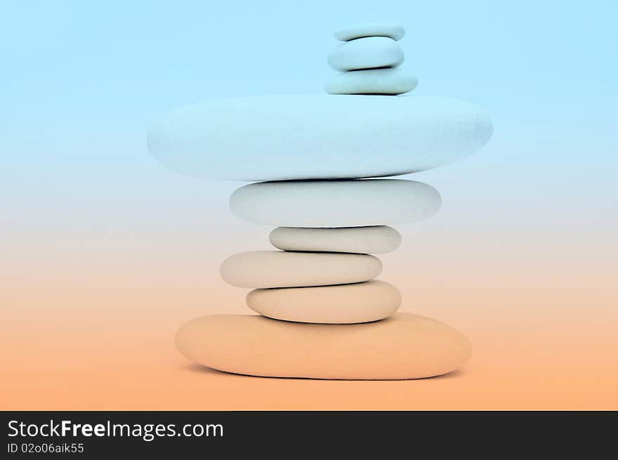 Stack of smooth stones over orange and white background. Stack of smooth stones over orange and white background