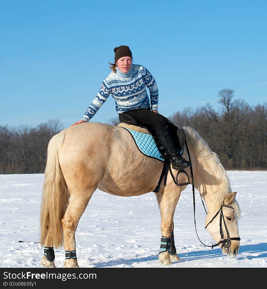 Winter image of the farm girl sitting on horseback